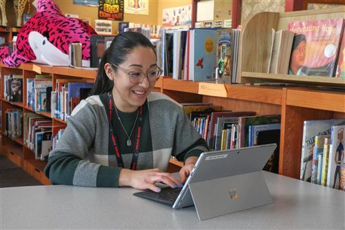 A staffer works on a laptop