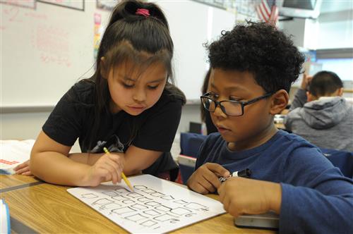 Two students work together on a worksheet