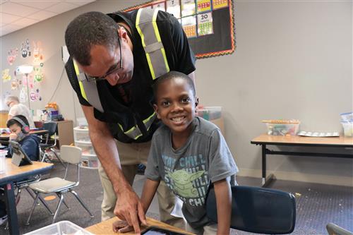 A security guard engages with a smiling student