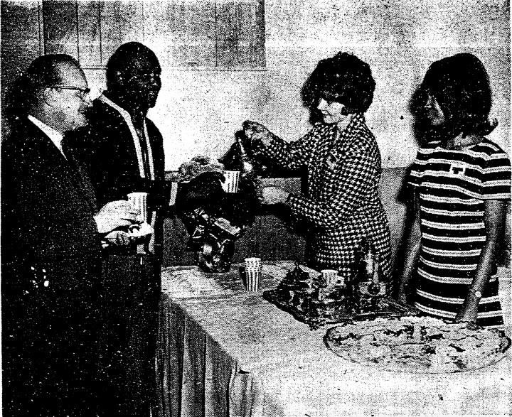 Two women serve coffee to two men