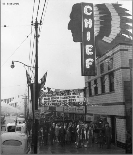 Exterior of Chief theater with neon sign and crowds