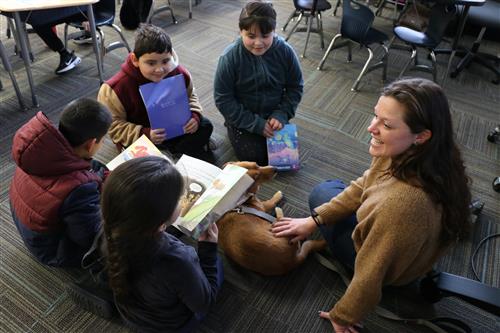 Kelsey Buglewicz-Miller and students read with therapy dog Sammy