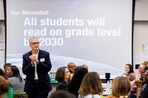 Matthew Ray in front of the Moonshot: All students will read on grade level by 2030
