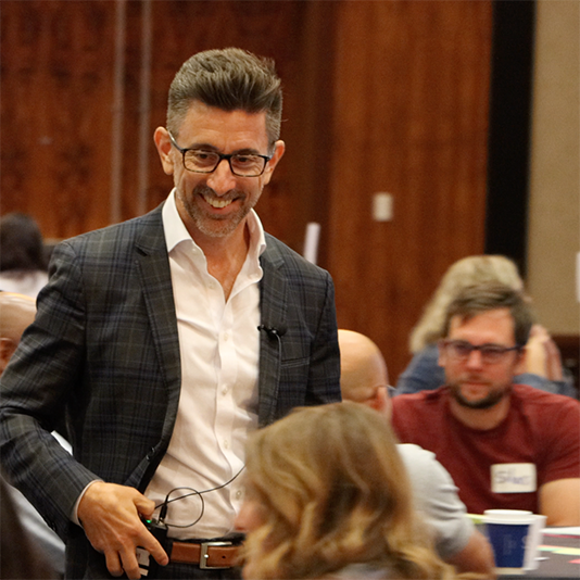  A presenter speaks to tables of teachers