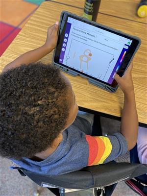 A student works on SeeSaw with his iPad