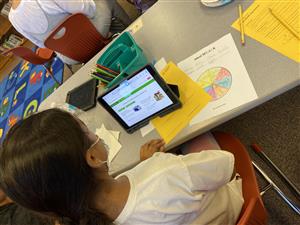 A student completes a digital citizenship activity with her mom