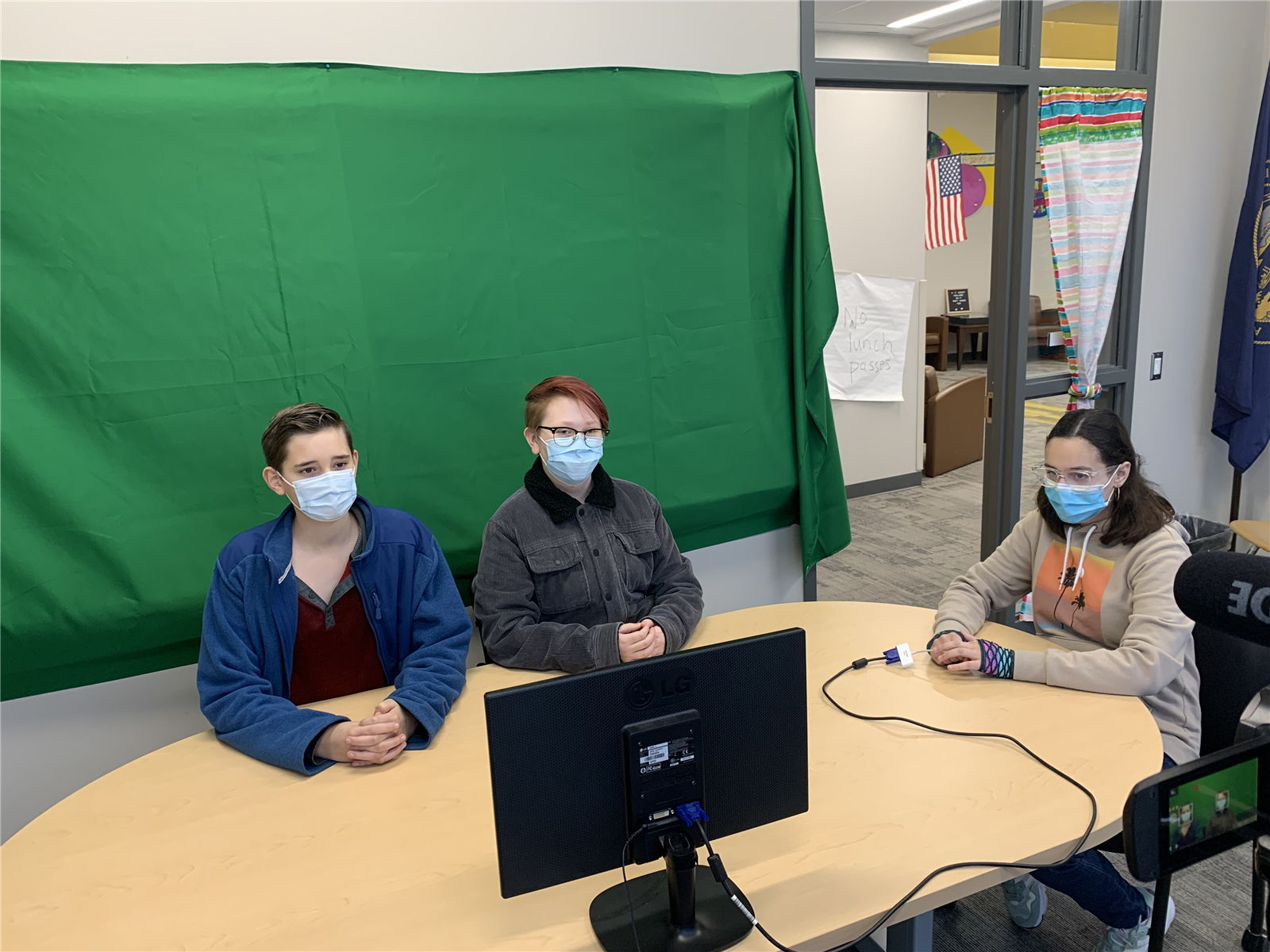Students filming annoncements with green screen.